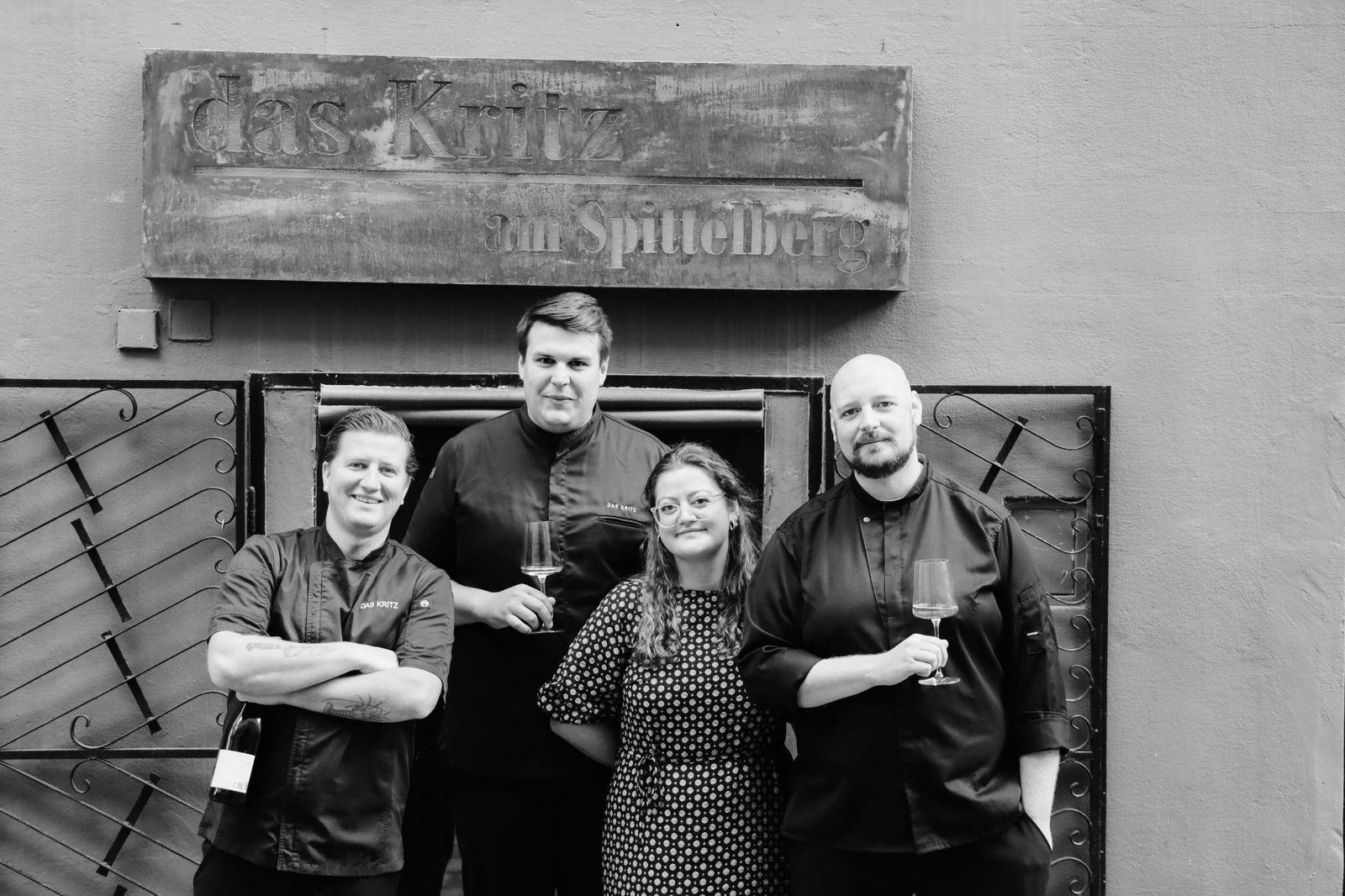 The das Kritz team in front of the entrance on Kirchberggasse, below the sign “das Kritz am Spittelberg” – from left: Nicolas Villarmé, Matteo Cottogni, Sophie Seifert and Benjamin Zeppelzauer